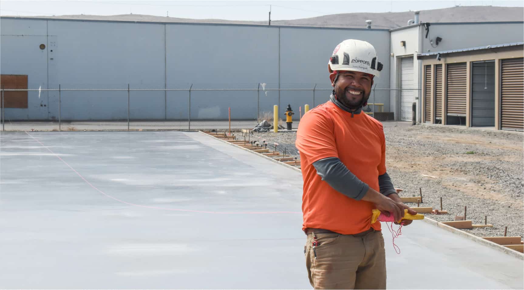 Smiling Poppoff employee in front of concrete slab