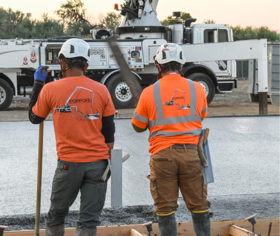 Two Poppoff workers overlooking freshly poured concrete slab