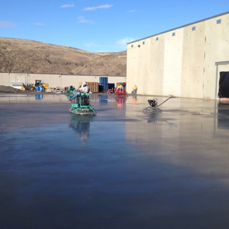 Concrete slab floor being smoothed by trowel machine