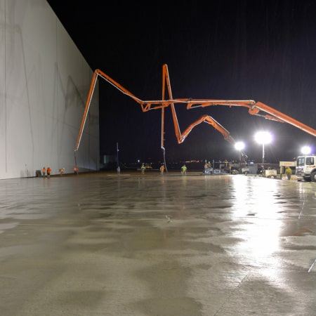 Leveled, fresh concrete slab with two concrete pumps