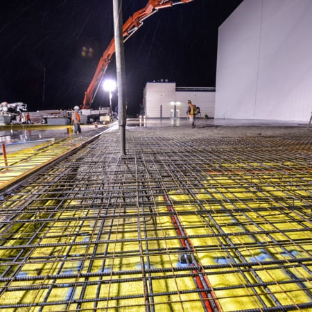 Concrete pump pouring concrete into steel rebar