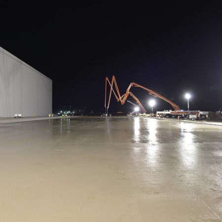 Leveled, fresh concrete slab with two concrete pumps