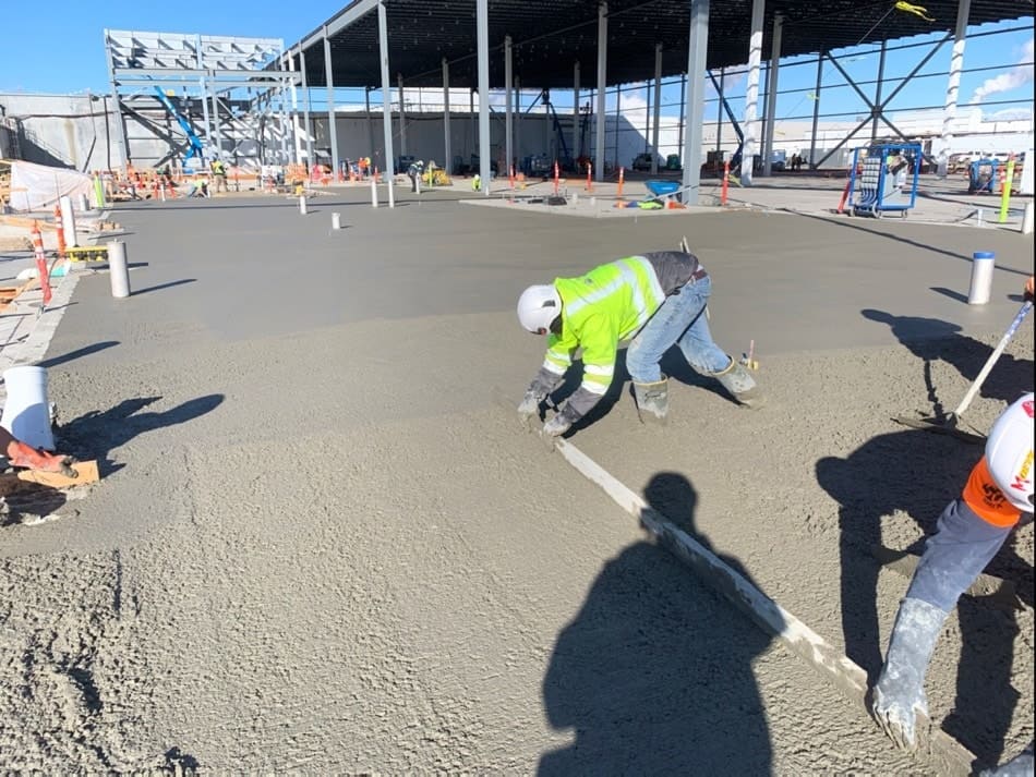 Concrete contractors smoothing concrete slab