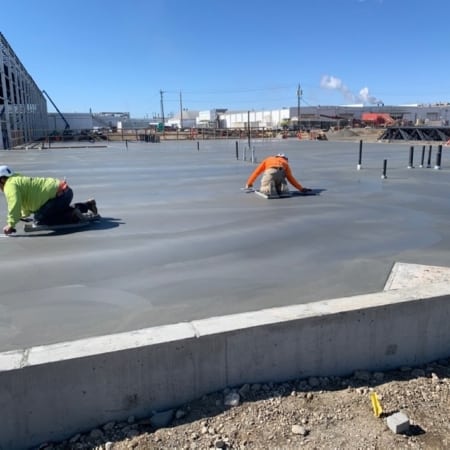 Concrete contractors smoothing concrete slab