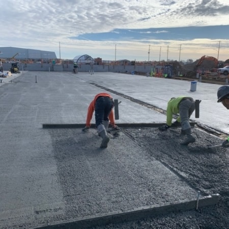 Concrete contractors smoothing concrete slab