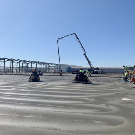 Commercial concrete slab with concrete pump in background