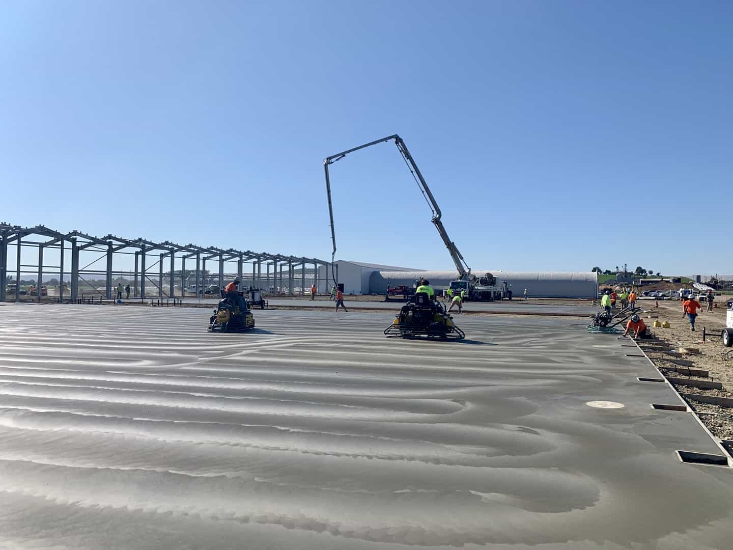 Commercial concrete slab with concrete pump in background