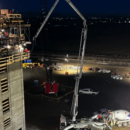 Concrete with raised boom pouring a formwork wall