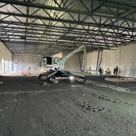 Spider boom concrete pump inside building during concrete flatwork project