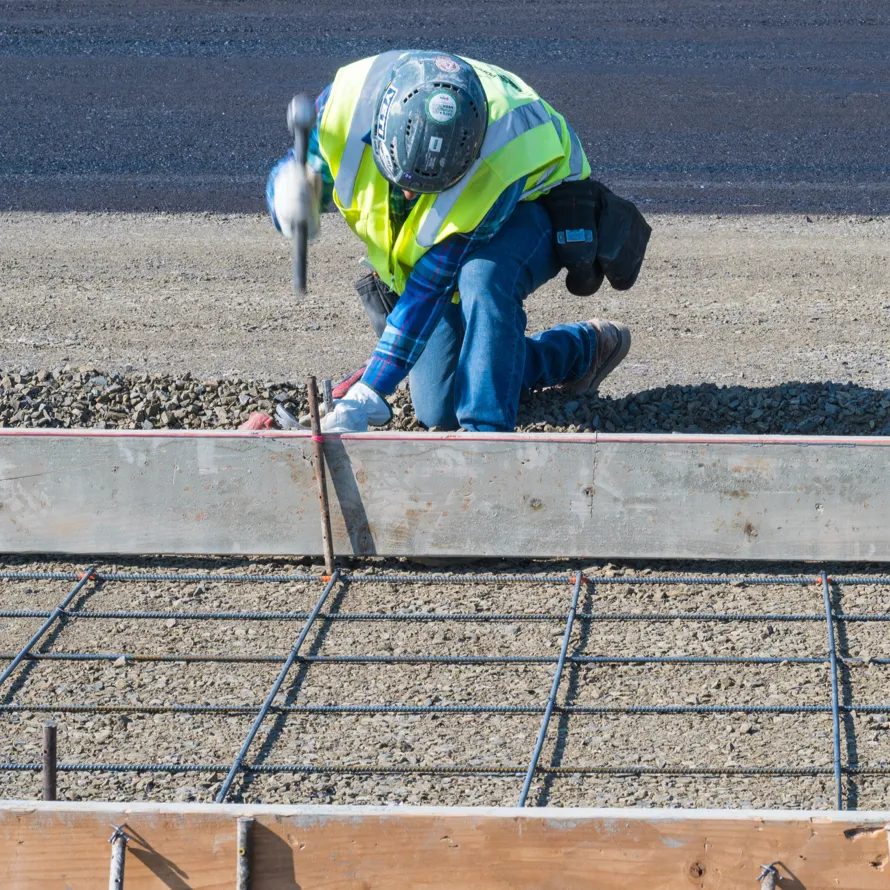 Carpenter hammering support rod for concrete formwork
